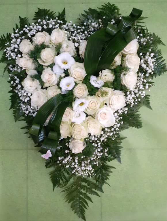 Composizione a cuore con fiori rossi e nastro